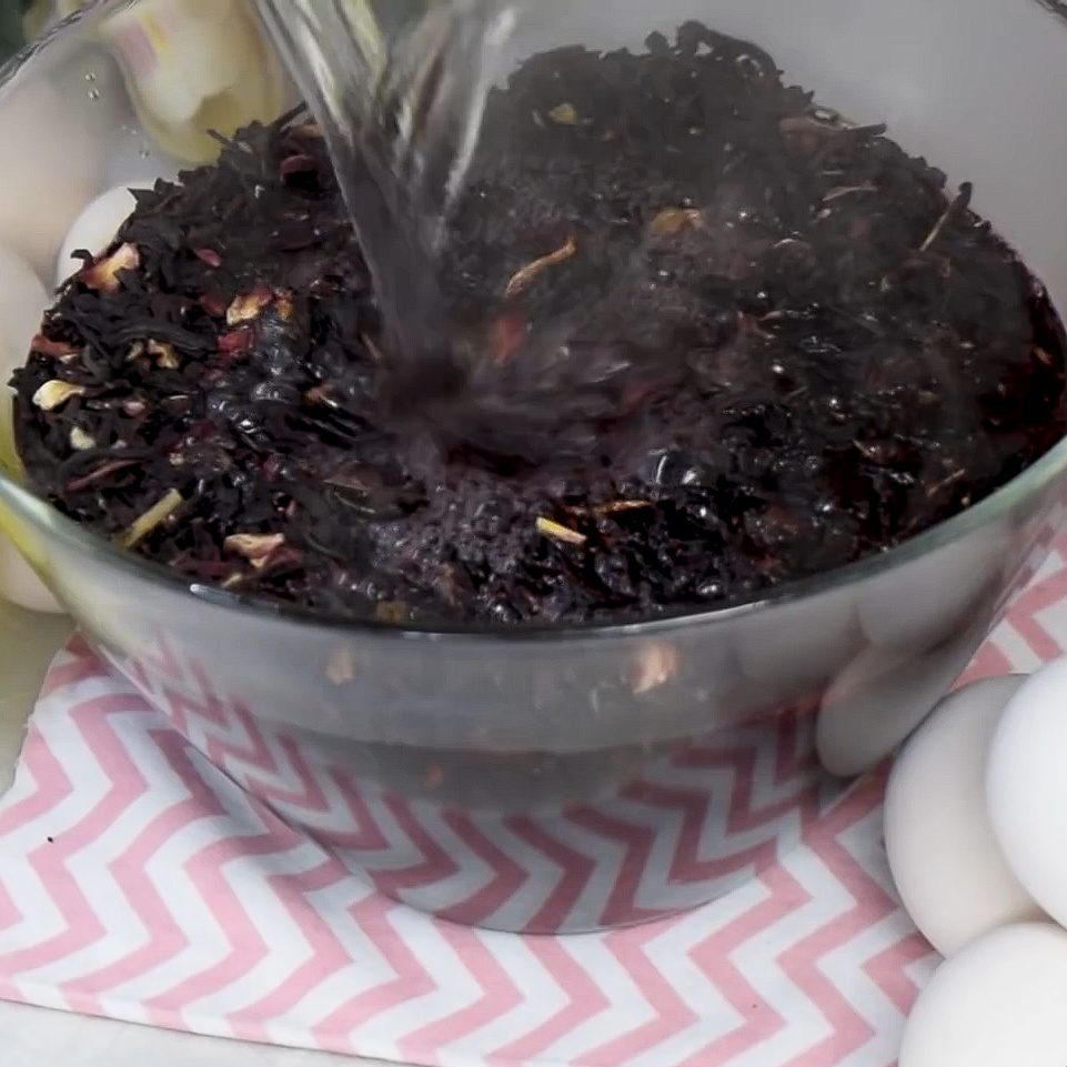 Woman fills bowl with Hibiscus tea to make beautiful dyed eggs for Easter