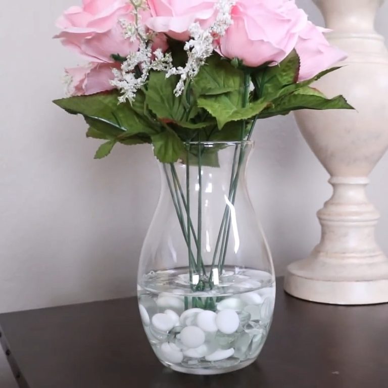Woman fills glass vase with Elmer’s glue for beautiful home decor hack