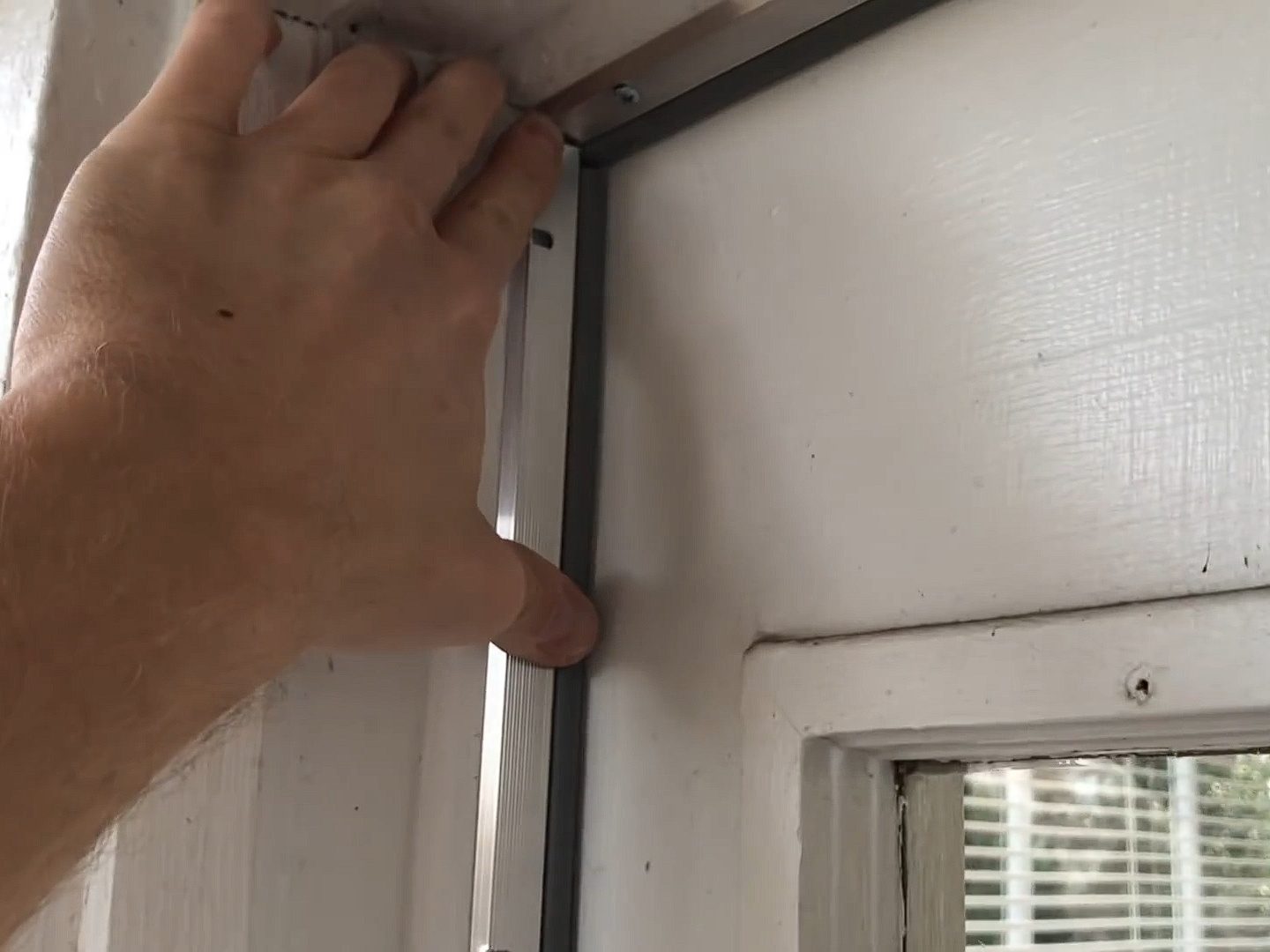 Man shows how to add weather stripping to old doors to keep heat in and