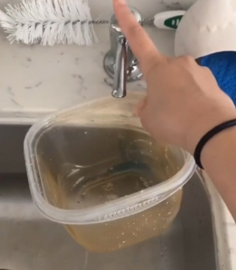 Young woman shows how to get grease stains out of Tupperware with