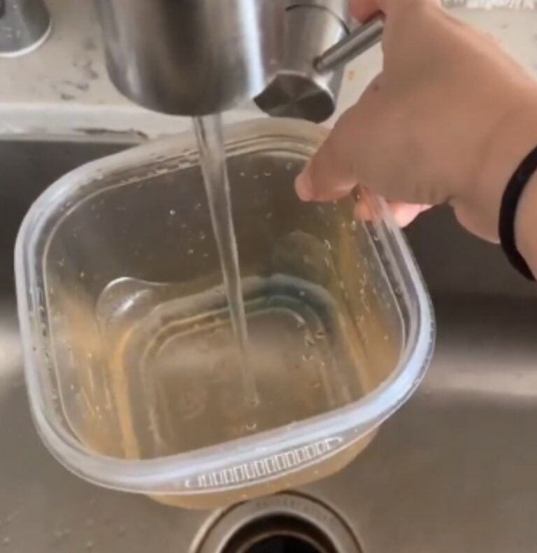 Young woman shows how to get grease stains out of Tupperware with