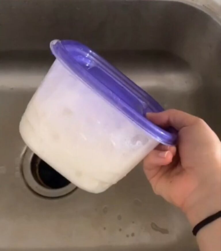 Young woman shows how to get grease stains out of Tupperware with